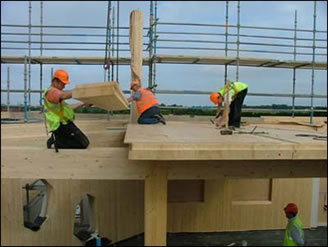 Workers fit timber floor panels on the building’s 3rd floor