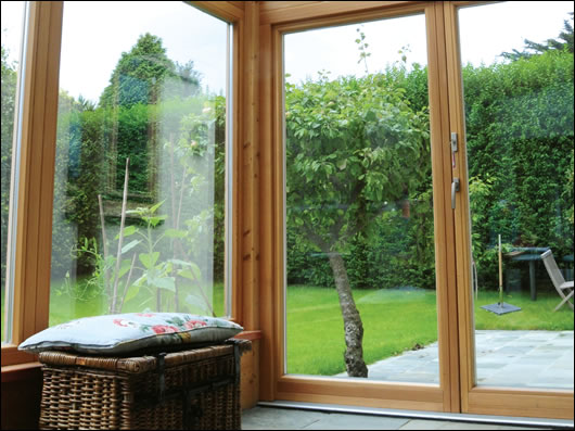 Looking out onto the garden from the sunroom, with slate floor for thermal mass and heat absorption, and solar shading on the roof to prevent overheating Looking out onto the garden from the sunroom, with slate floor for thermal mass and heat absorption, and solar shading on the roof to prevent overheating