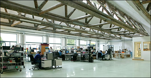 Timber trusses dominate the extensively glazed north-facing factory floor, which was polished mechanically, thus avoiding the use of any chemical products or additional materials Timber trusses dominate the extensively glazed north-facing factory floor, which was polished mechanically, thus avoiding the use of any chemical products or additional materials