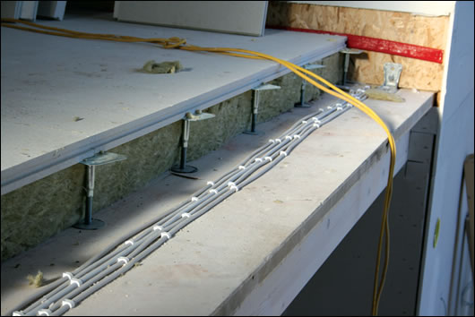 (above) the schamotte fire bricks of the kachelofen being fired; (below) the floor build up includes Fermacell slabs suspended on pedestals, and 160mm of Rockwool insulation (above) the schamotte fire bricks of the kachelofen being fired; (below) the floor build up includes Fermacell slabs suspended on pedestals, and 160mm of Rockwool insulation