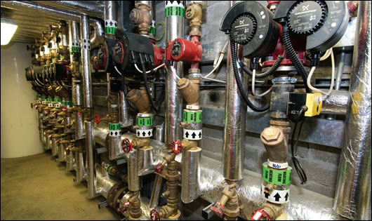 a view of some of the system’s pumps and pipes, with the preheat tank in the background a view of some of the system’s pumps and pipes, with the preheat tank in the background