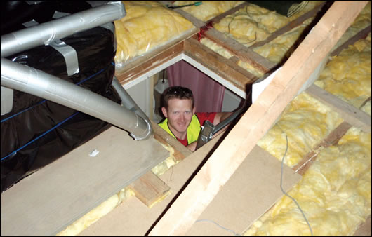 A contractor installing fibreglass insulation A contractor installing fibreglass insulation