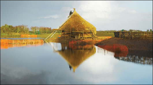 The crannog - showing its waterside position and dominant thatch roof The crannog - showing its waterside position and dominant thatch roof